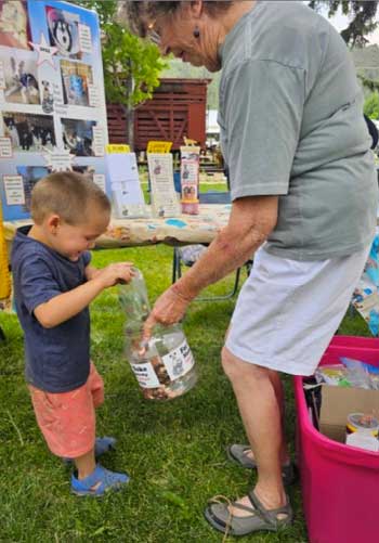 A child donates change to For Pets' Sake at Dolores Farmers Market